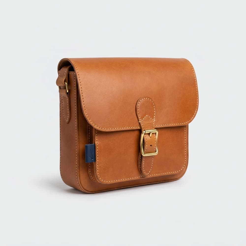 Handcrafted full-grain tan leather messenger bag with saddle stitching