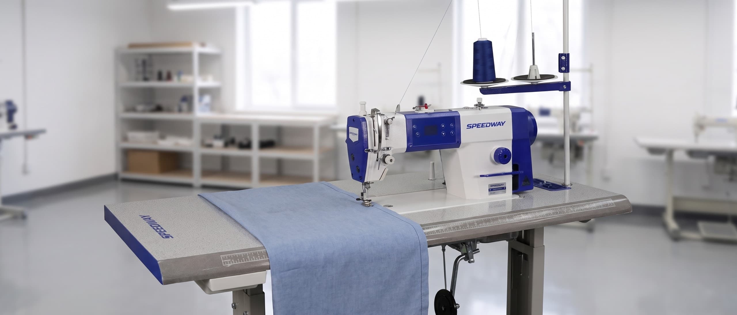 Industrial single-needle lockstitch sewing machine sewing a fine cotton dress shirt seam at production speed