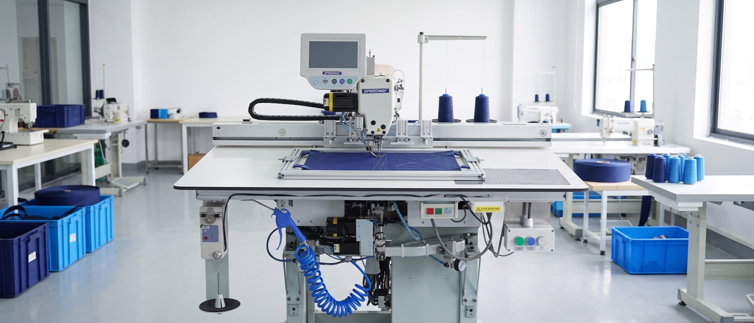 SPEEDWAY SW 800-8045XH extra-heavy CNC template sewing machine stitching a programmed pattern on a navy webbing panel clamped in its moving template frame